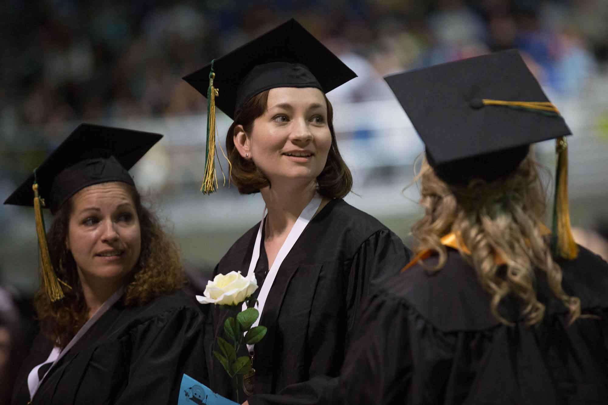 Three students graduating at commencement